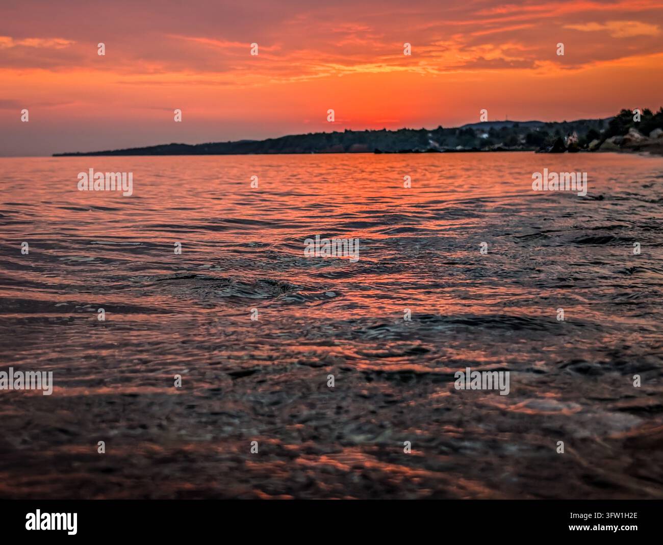 Superficie del mare nella luce rosa del tramonto, Nikiti, Sithonia, Calcidica, Grecia Foto Stock