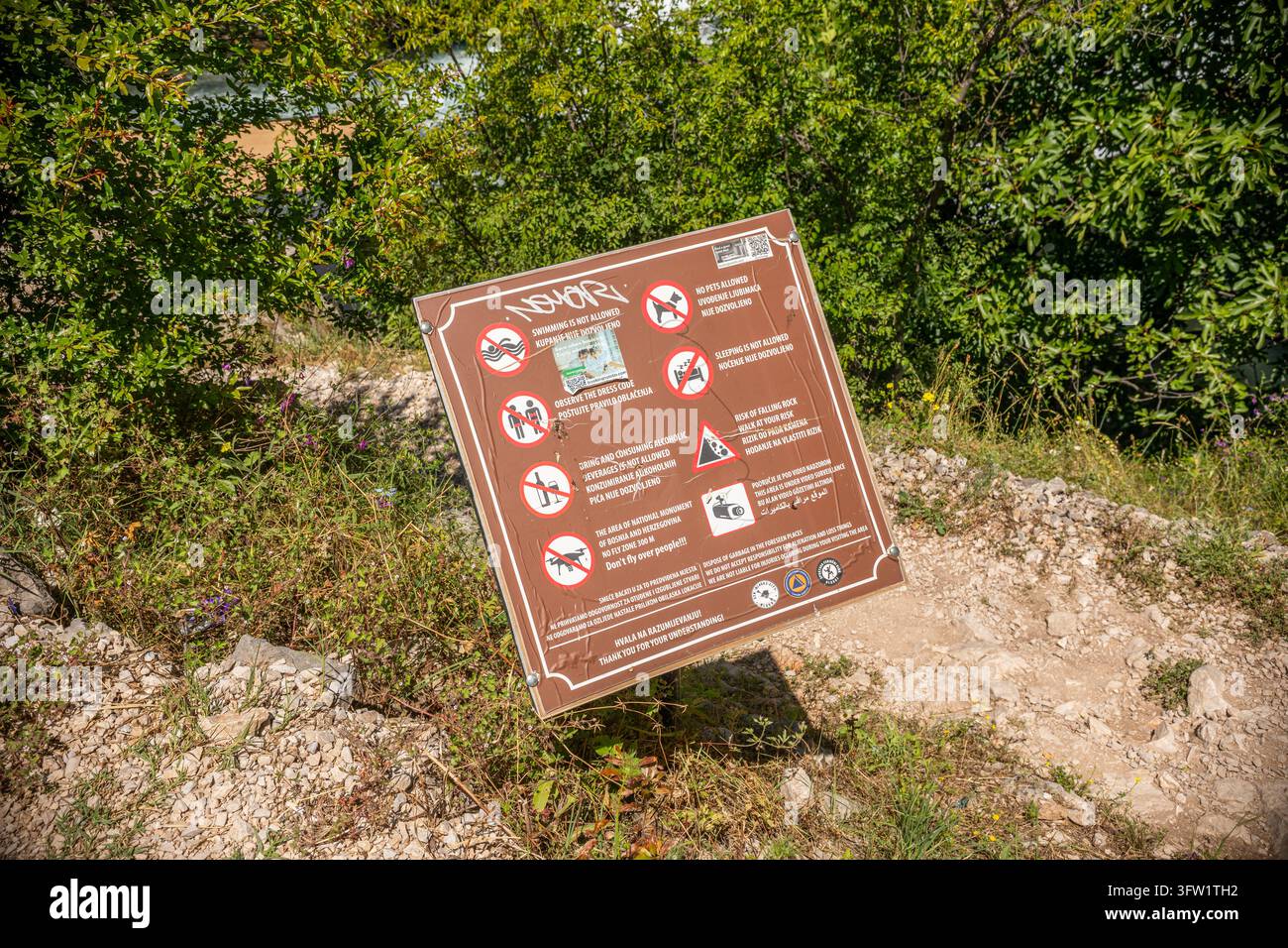 Bosnia ed Erzegovina, Blagaj 2025 05 28: Cartello di avvertimento con le regole alla sorgente della Buna, scatto all'altezza degli occhi. Foto Stock