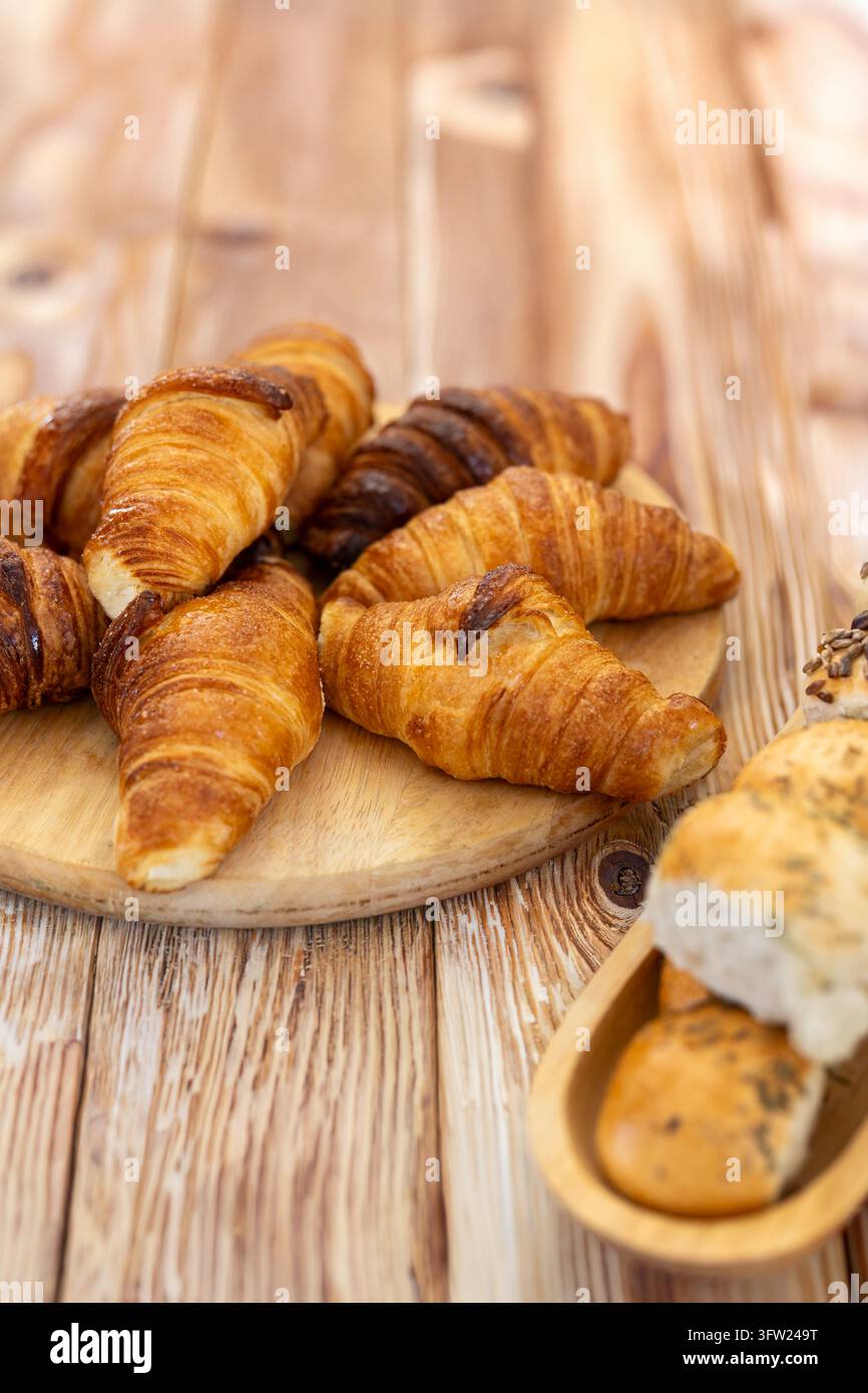 Tavolo rustico con pasta fresca artigianale appena sfornata, croissant dolci e mini focacce salate per una colazione in panetteria. Foto Stock