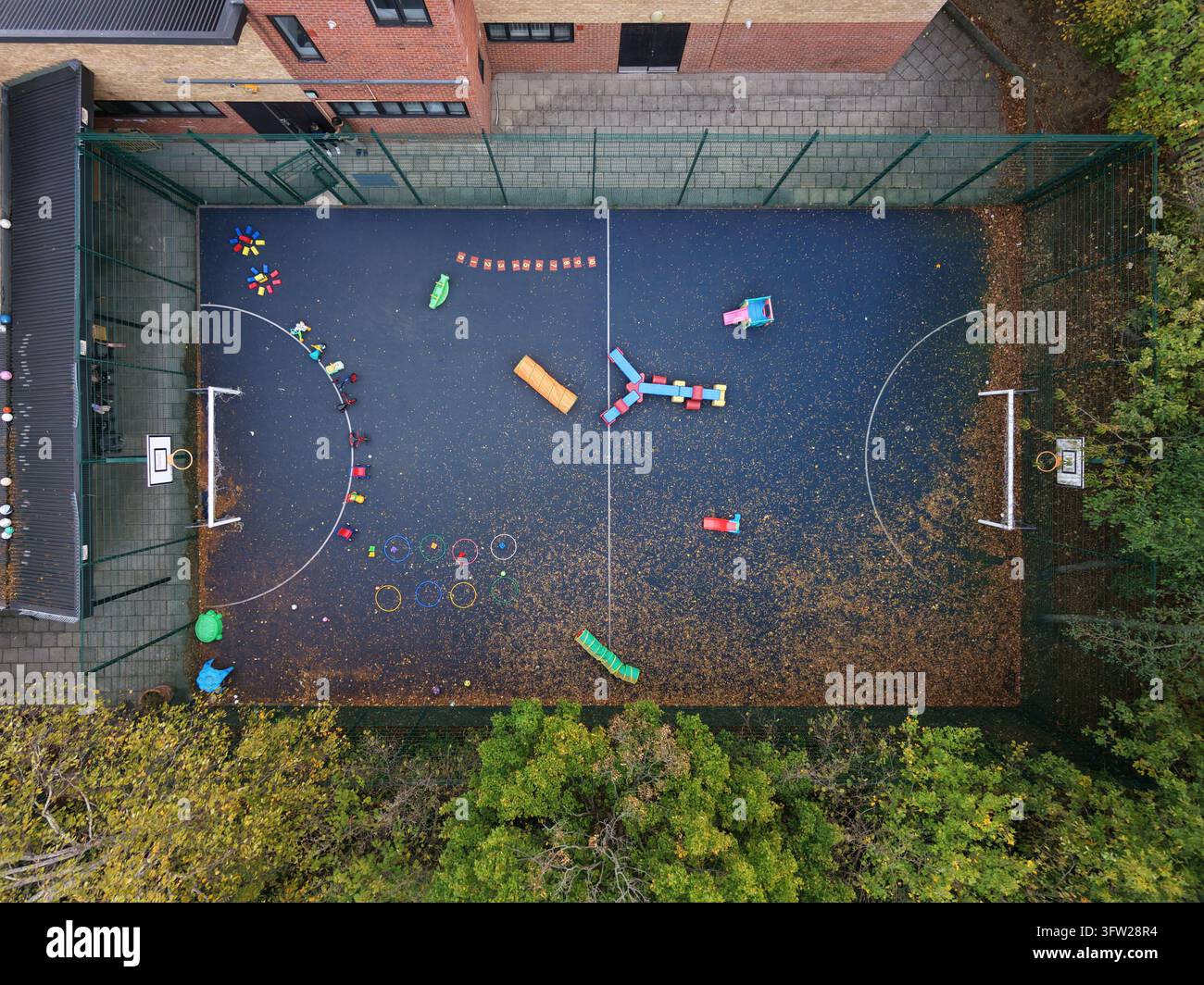 I giocattoli sono disposti su un campo recintato per il gioco all'aperto dei bambini. Questo è stato scattato al Southall Havelock Children's Centre Foto Stock