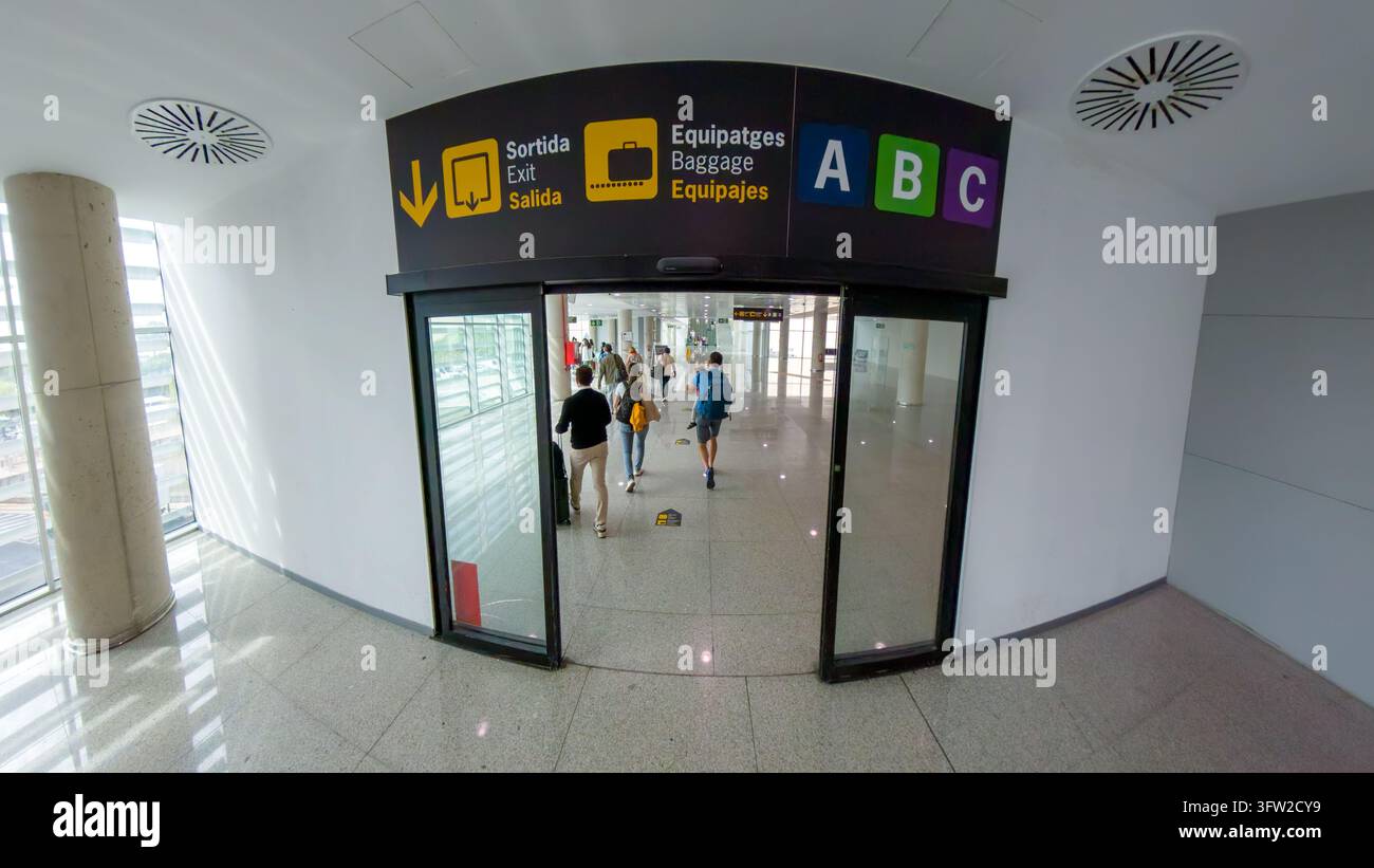 Uscita dell'aeroporto segnalata e percorso per i bagagli con marcatori A, B e C sopra le porte a vetri scorrevoli dell'aeroporto di Palma di Maiorca. Foto Stock