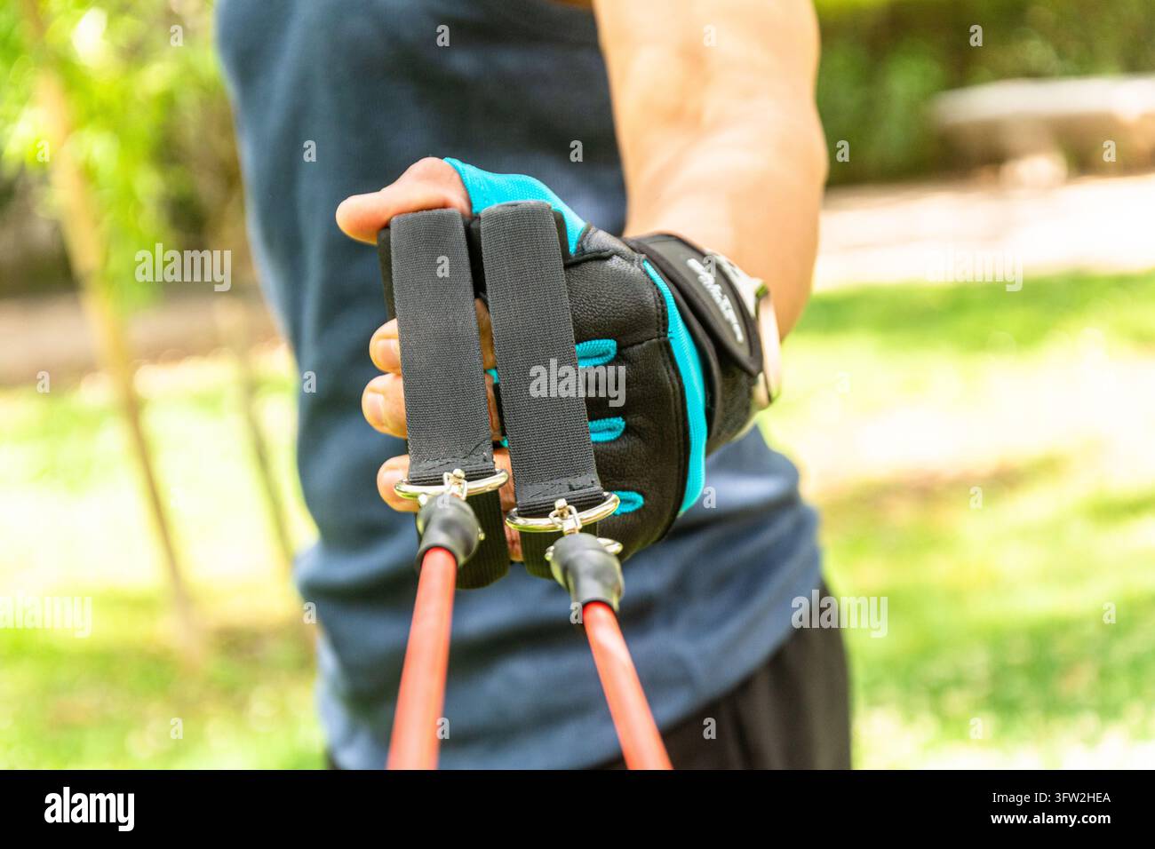 Uomo che si allena con un nastro di resistenza nel parco Foto Stock