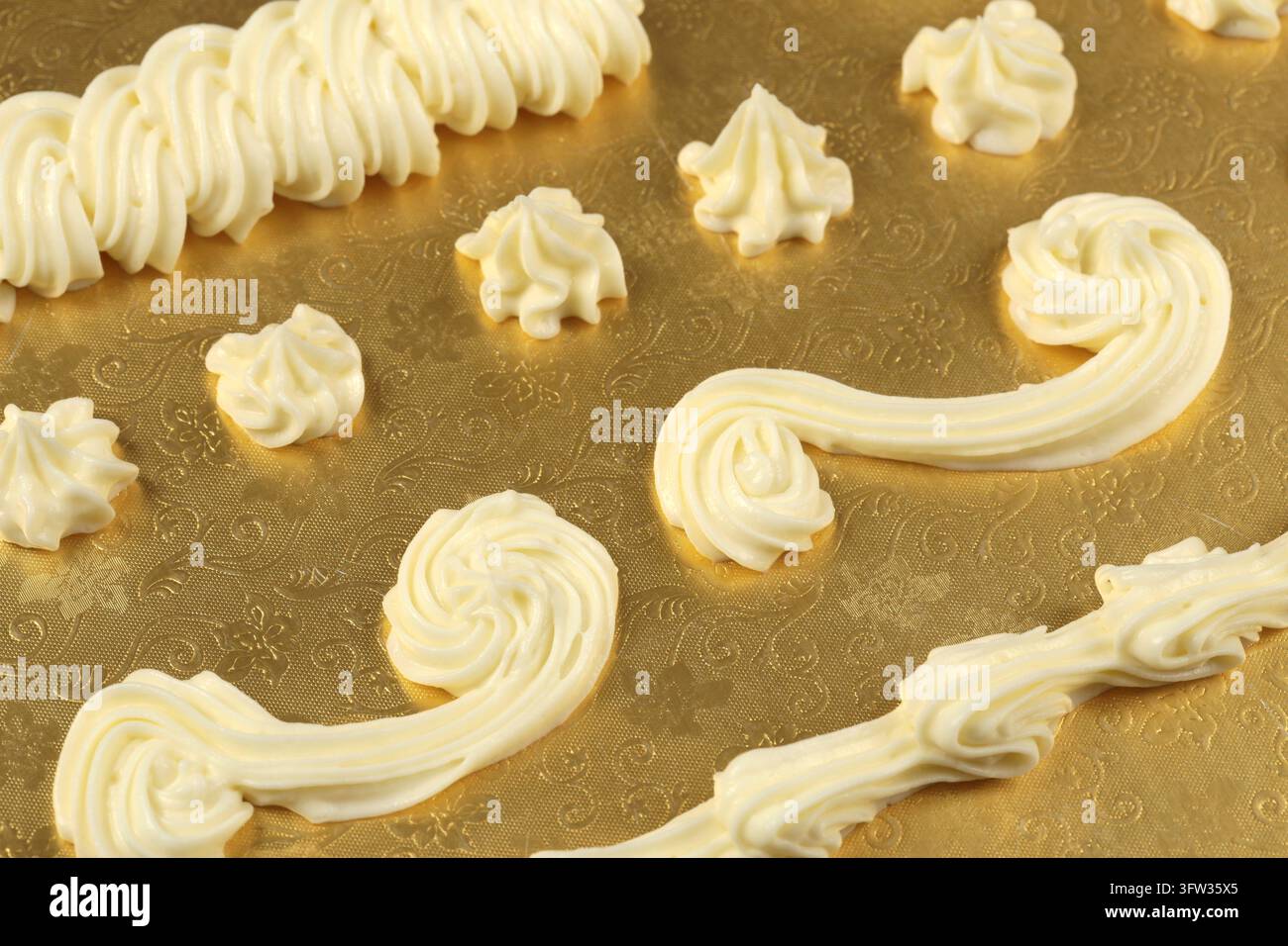Decorazione in panna montata su sfondo dorato Foto Stock