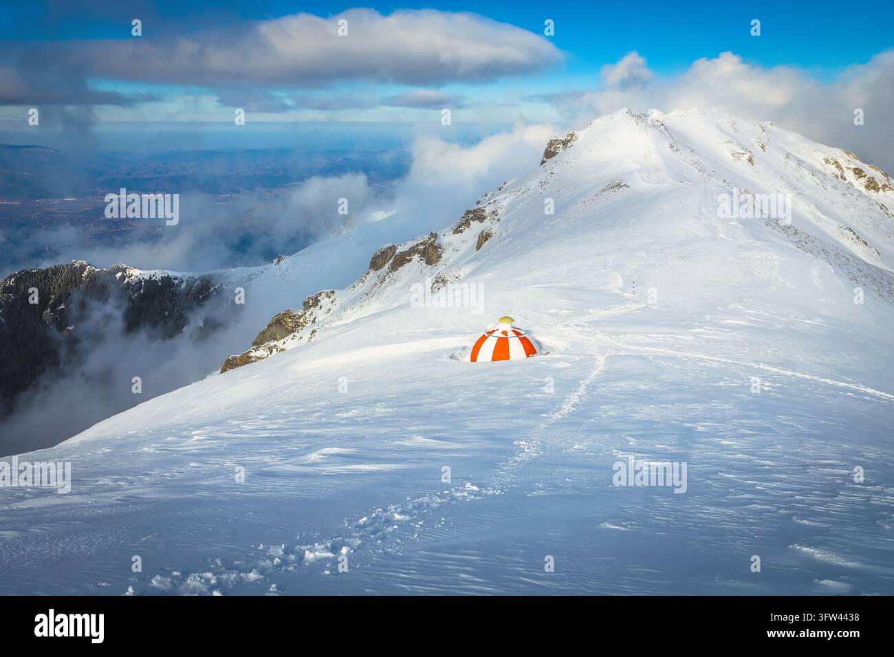 Bellissimo scenario invernale con bivacco in montagna e riparo sulla cresta innevata Foto Stock