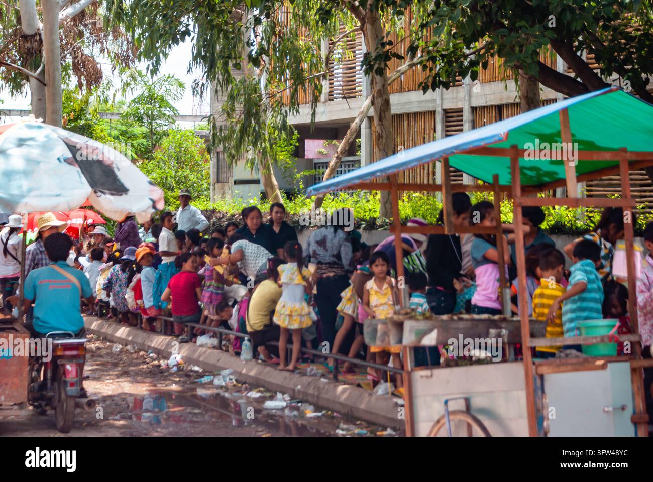 SIEM REAP, CAMBODIA - 28 LUGLIO 2011: Famiglie e bambini si riuniscono lungo un'area di mercato stradale a Siem Reap, in Cambogia, socializzando, facendo acquisti e passando del tempo Foto Stock