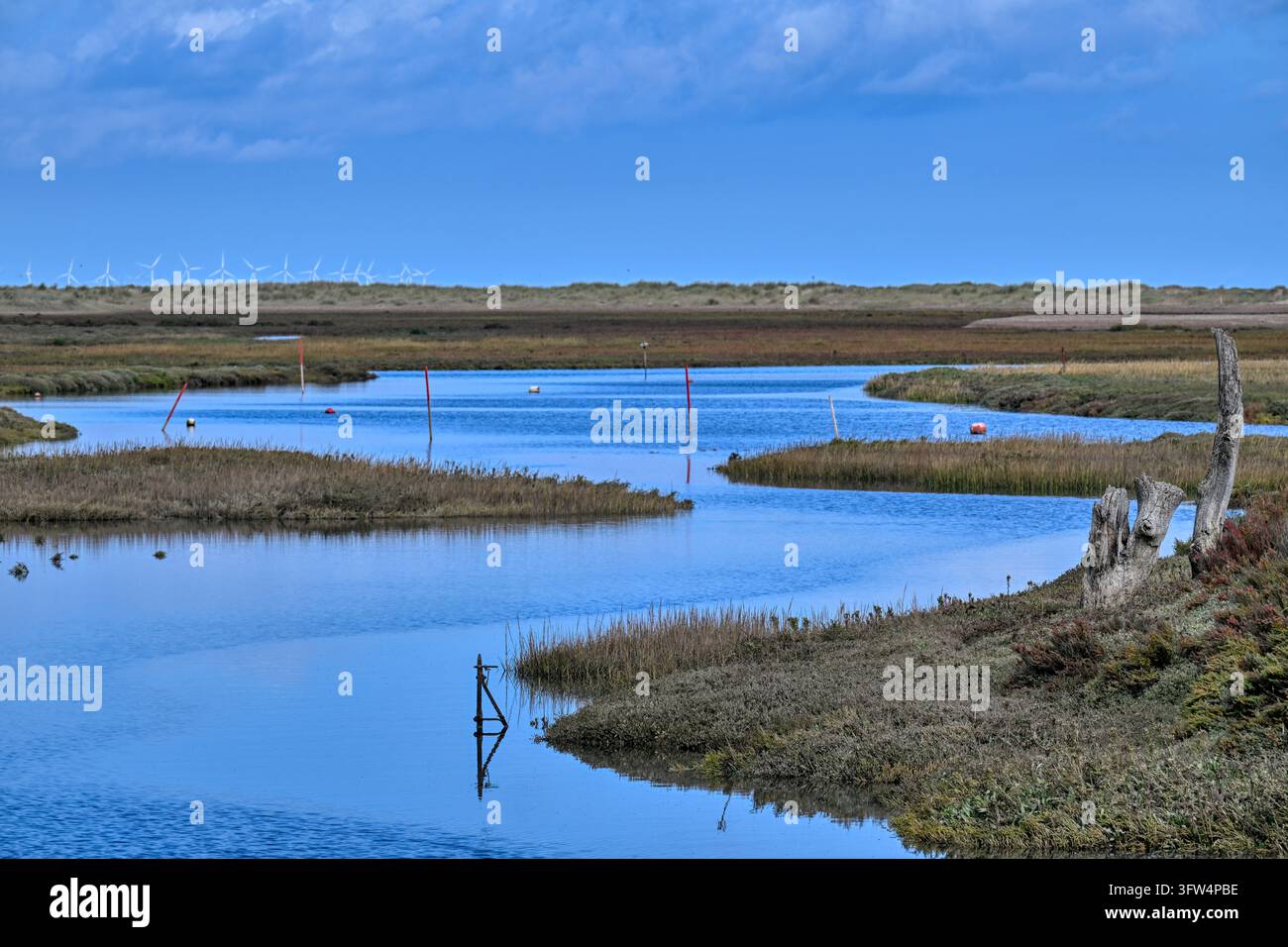 Una vista lungo il canale del porto verso le paludi e il mare a Thornham, Norfolk, Regno Unito Foto Stock