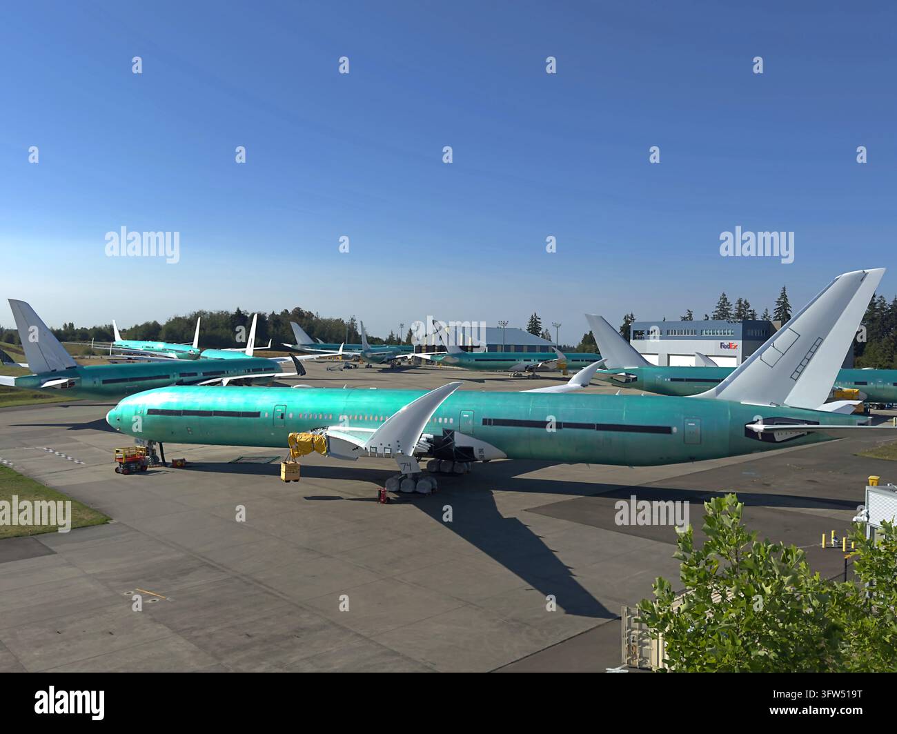 Aereo passeggeri Boeing 777X non verniciato con i winglet ripiegati parcheggiato all'esterno della fabbrica Boeing a Everett, Washington, Stati Uniti. Foto Stock