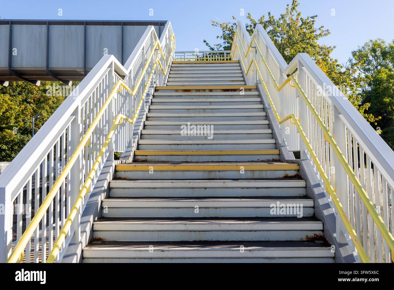 Scalinata pedonale che conduce verso il cielo blu, stazione ferroviaria di Pewsey, Wiltshire, Inghilterra, Regno Unito Foto Stock