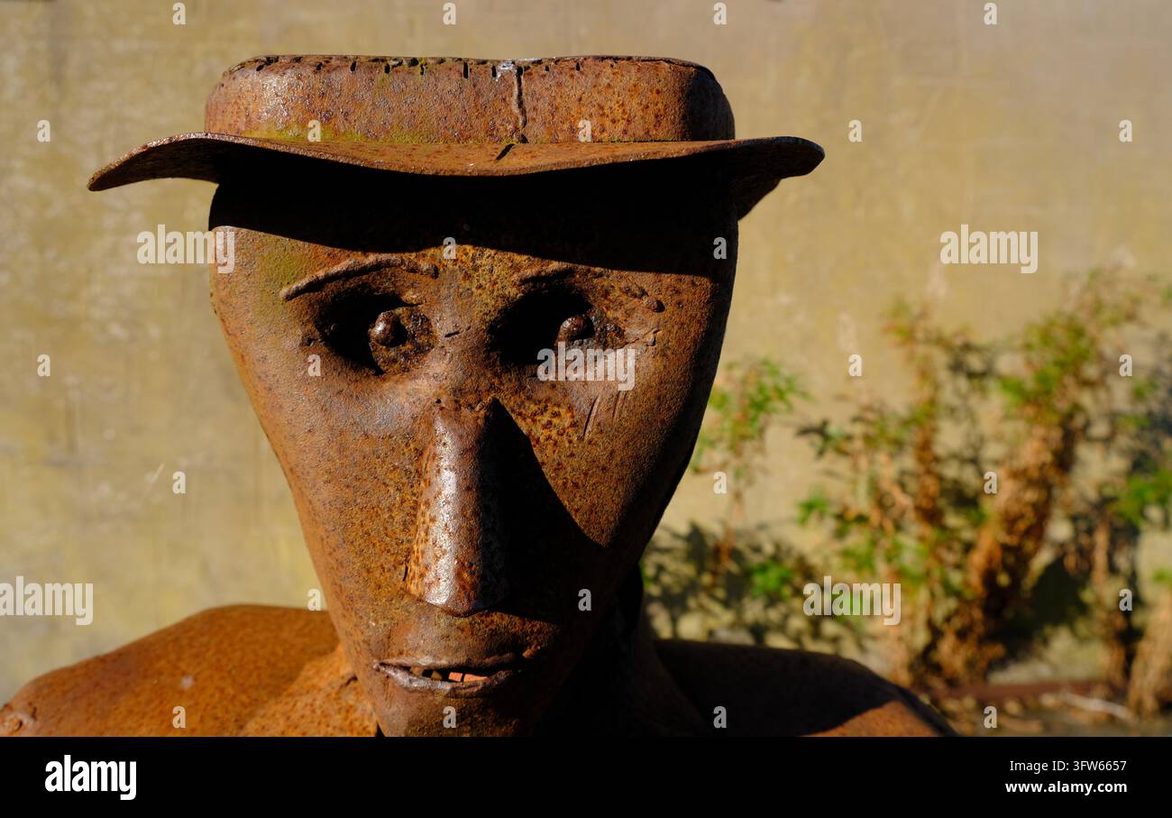 Dettaglio consumato di una scultura di uomo in rottame arrugginito con cappello, esposta sul Sentiero di Arte e Artigianato pubblico a Kirkcudbright, Scozia Foto Stock