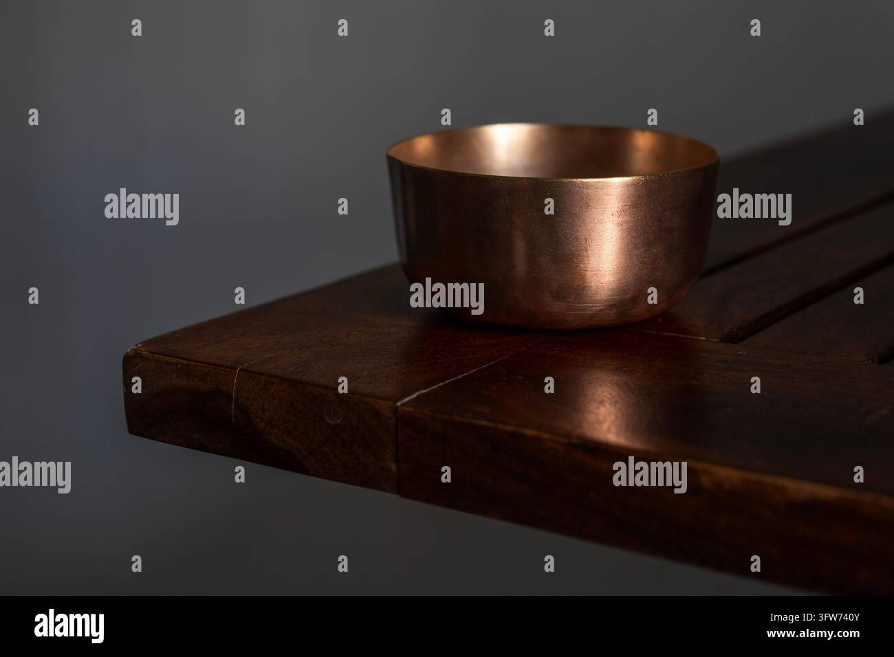 Vasi tradizionali indiani in ottone e rame su una superficie in legno. Ciotole vintage in rame e ottone per rituali ayurvedici e still life indiano Puja. Foto Stock