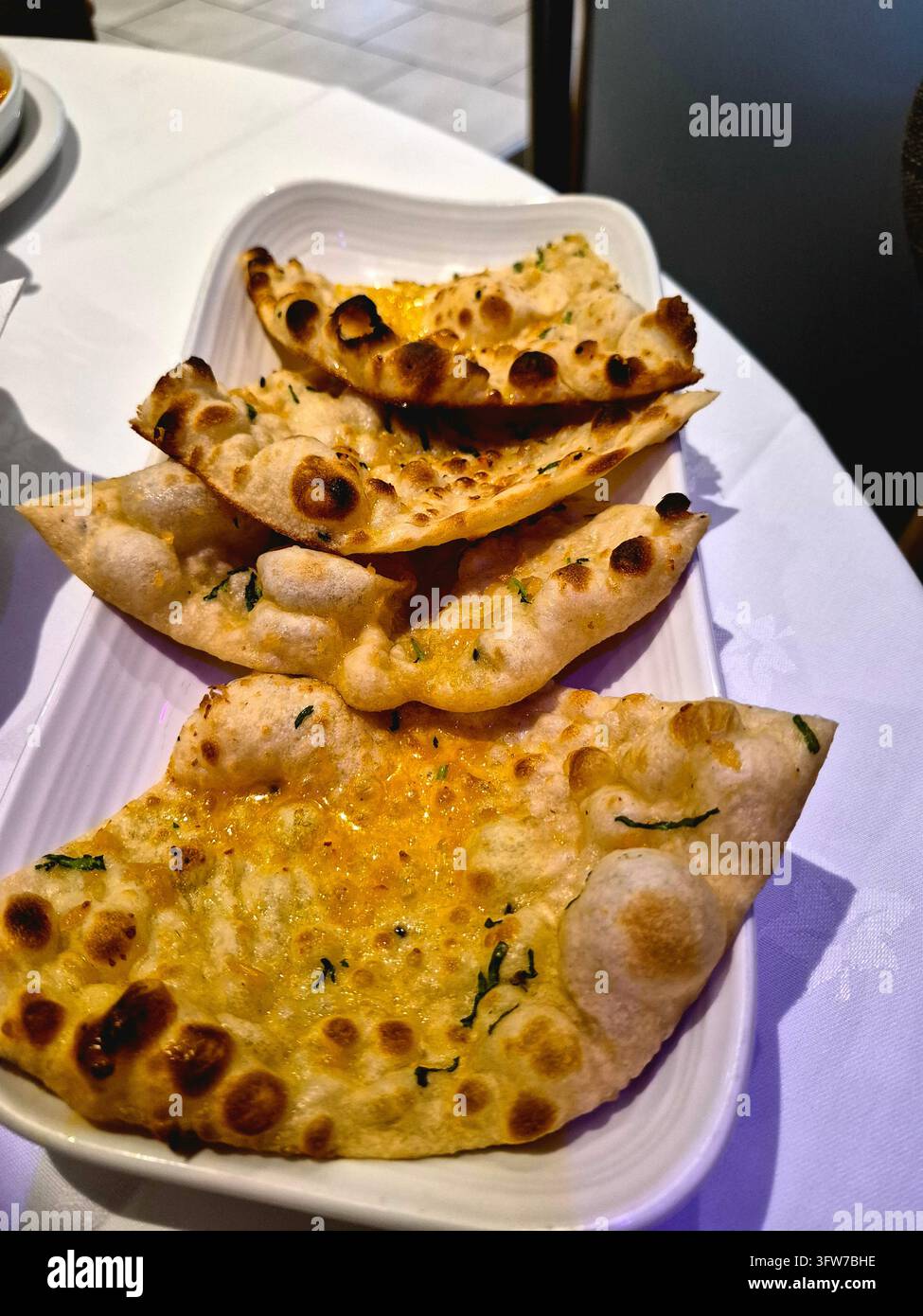 Piatto di naan all'aglio, o pane naan, in un ristorante indiano nel Sussex, UK Foto Stock