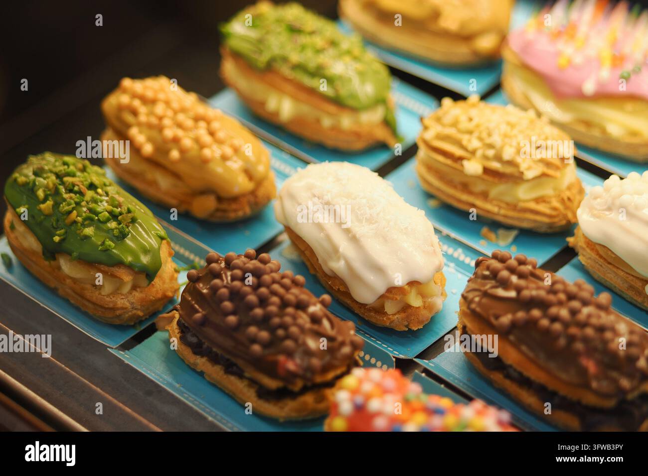 guscetti di choux francesi tradizionali ripieni di crema pasticcera e guarniti con noci e cioccolato Foto Stock