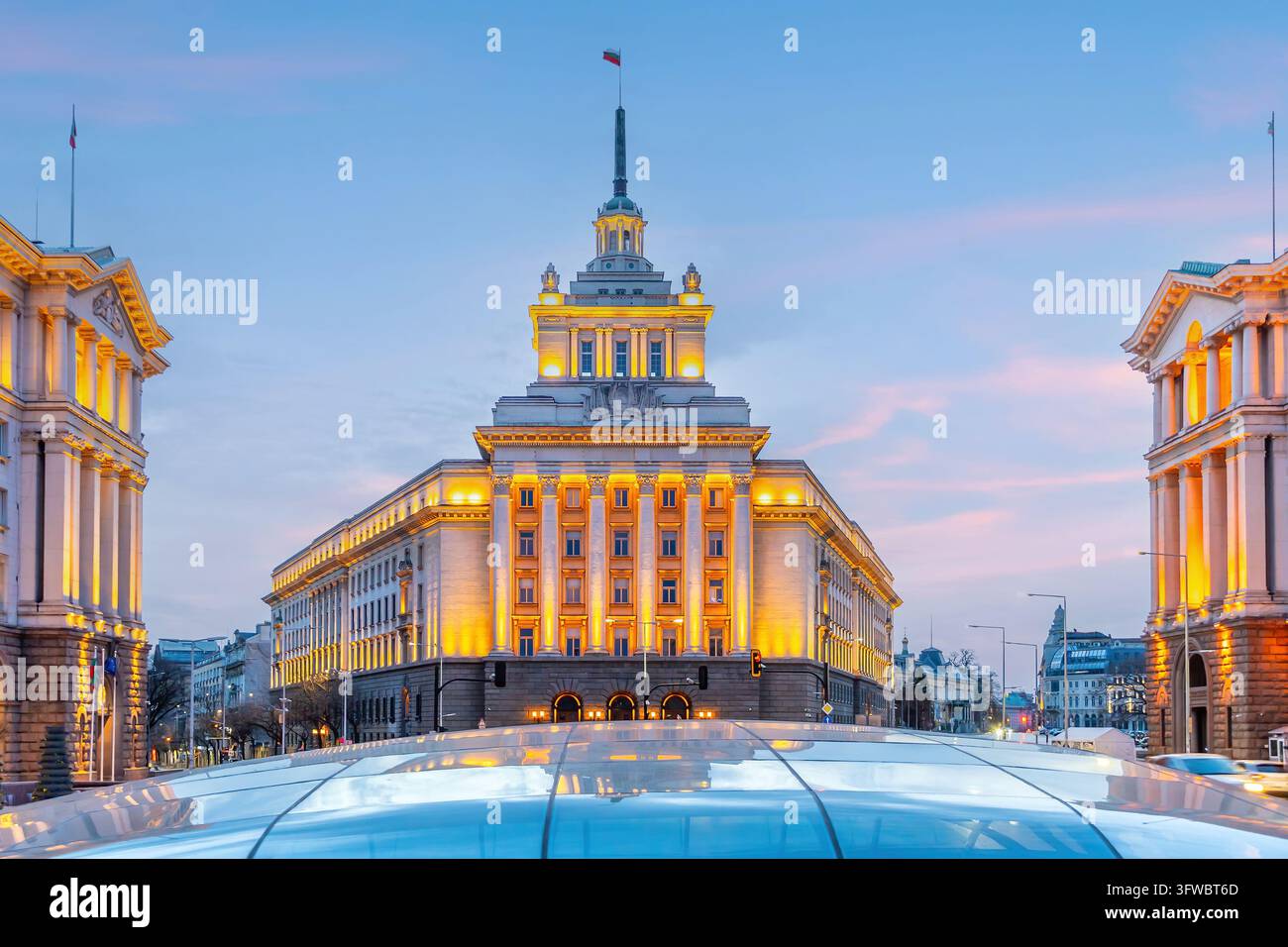 Piazza dell'Indipendenza a Sofia, Bulgaria, con l'architettura classicista socialista della Casa del Partito e degli edifici governativi illuminati al tramonto Foto Stock