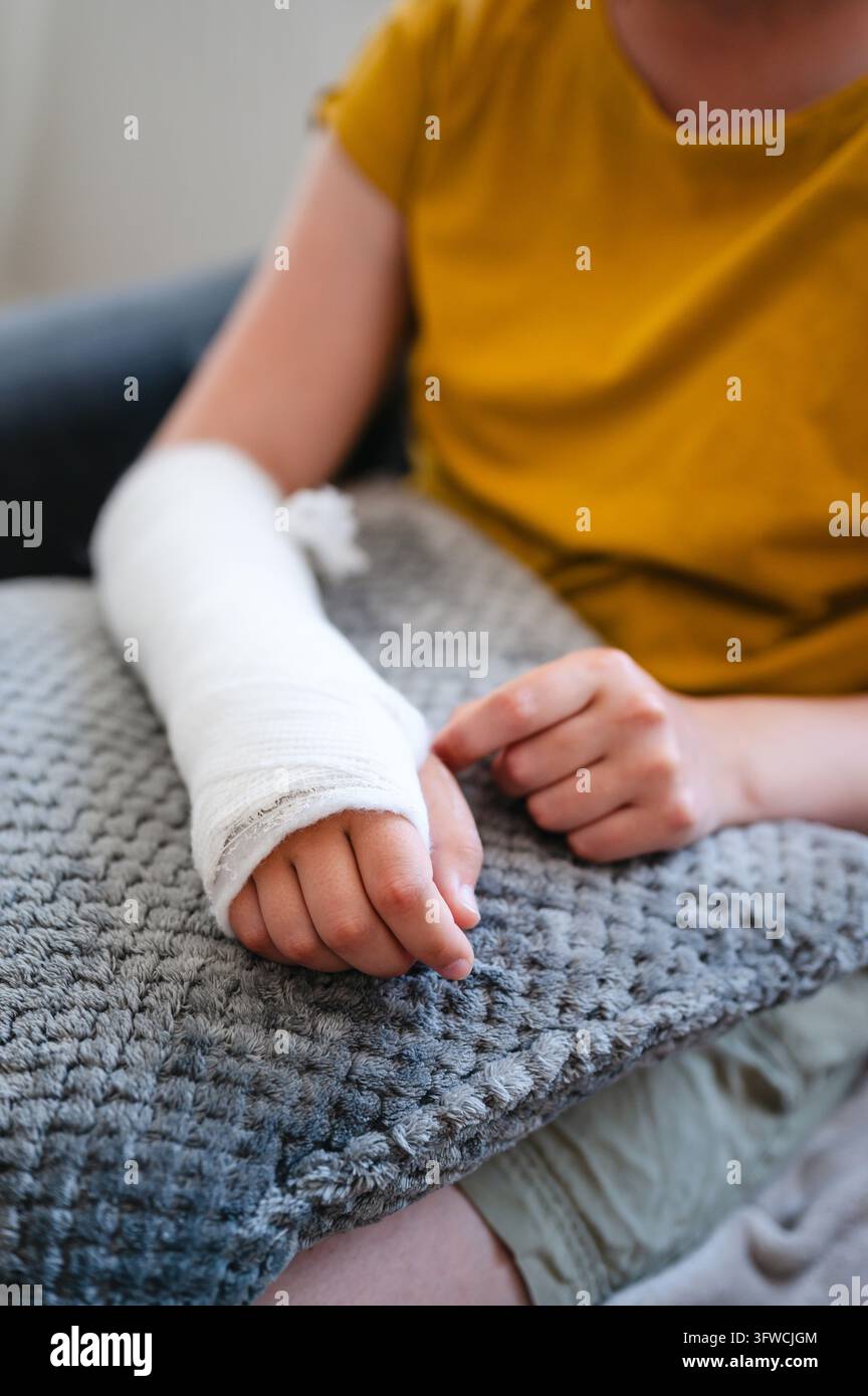 Primo piano di un braccio ferito ingessato appoggiato su un cuscino Foto Stock