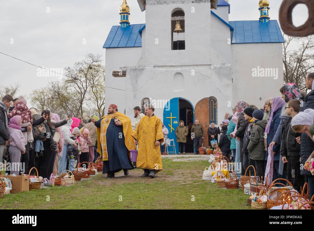 POLTAVA, UCRAINA – 12 APRILE 2026: Persone si radunano fuori da una chiesa per la benedizione tradizionale di Pasqua Foto Stock