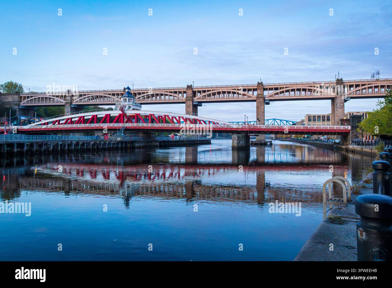 Ponte oscillante con ponte ad alto livello sullo sfondo attraverso il fiume Tyne Foto Stock