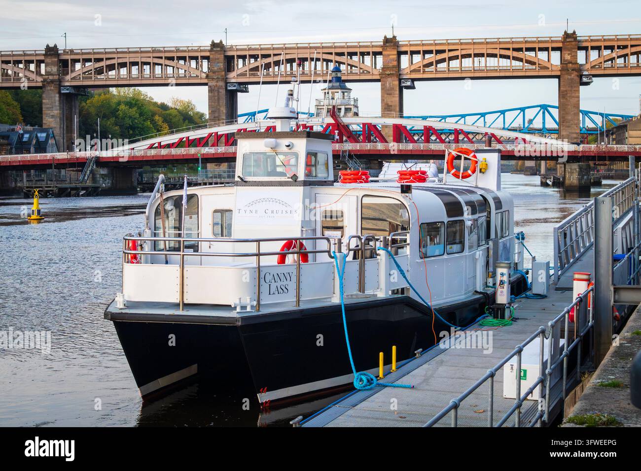 Barca da diporto 'Canny Lass' ormeggiata al molo di Newcastle upon Tyne in una luminosa mattina d'autunno con vari ponti che attraversano il Tyne sullo sfondo Foto Stock