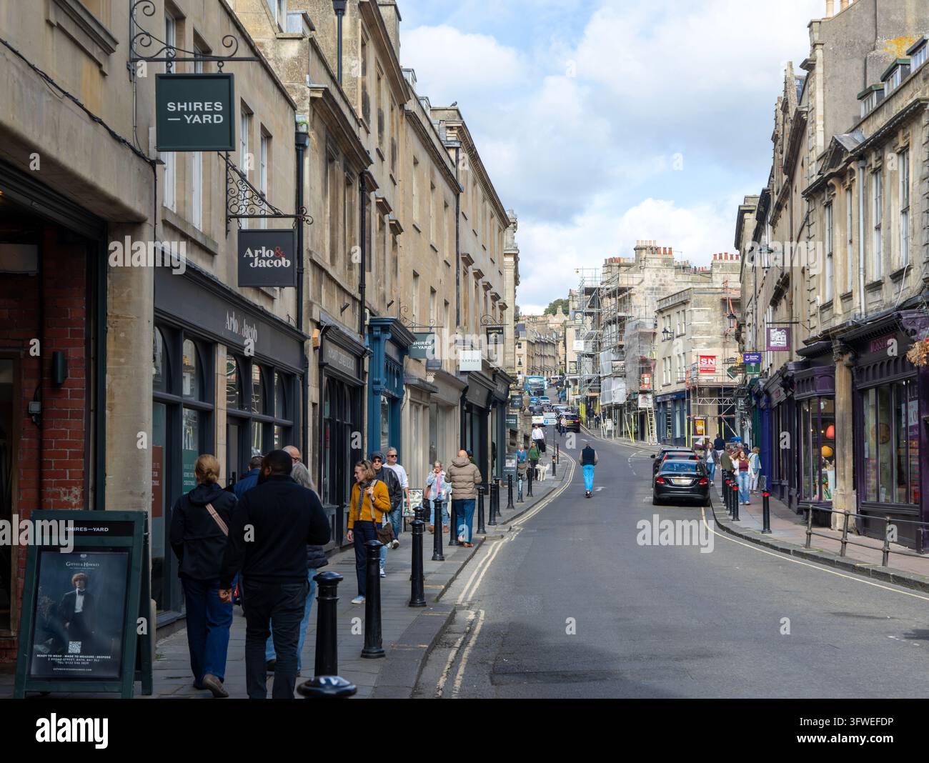 Negozi indipendenti in Broad Street con vista verso l'alto verso Lansdown, centro città di Bath, Somerset, Inghilterra, Regno Unito Foto Stock
