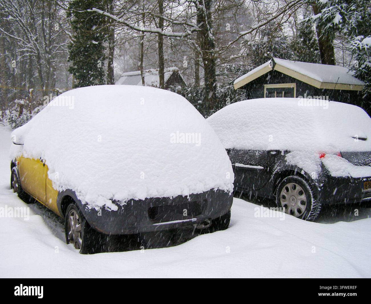 Auto sepolte sotto una spessa neve pesante, tra cui una Ford Ka gialla e una Renault grigia Foto Stock