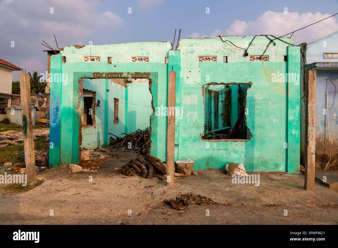 Ex casa tamil distrutta dalla guerra con pareti verdi e finestre rotte, Provincia Settentrionale, Jaffna, Sri Lanka Foto Stock