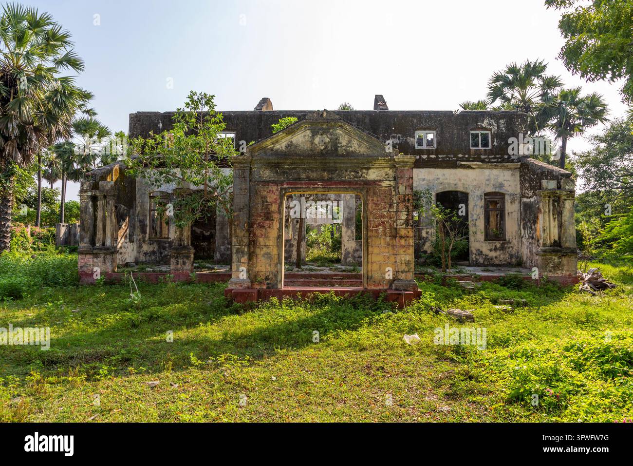 Rovine di una villa coloniale abbandonata in un campo erboso, Provincia Settentrionale, Jaffna, Sri Lanka Foto Stock