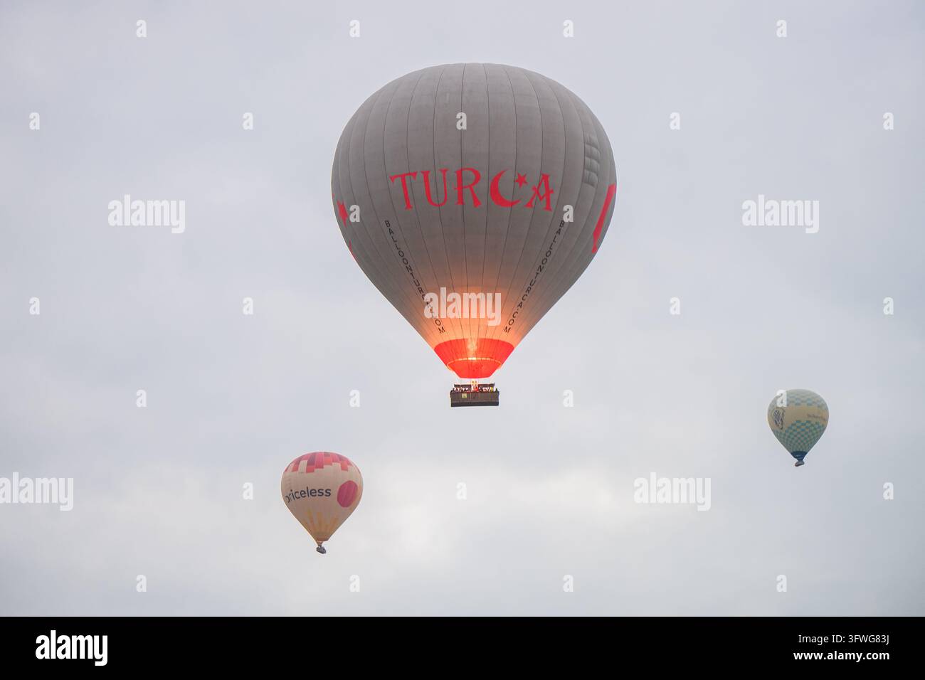 CAPPADOCIA, TURCHIA - 25 MAGGIO 2026: Vista dettagliata di un enorme pallone aerostatico grigio della compagnia Turca che si eleva. Un aerostato di minor valore sfocato sullo sfondo Foto Stock