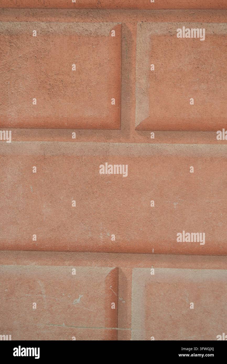 Facciata in muratura dipinta a Genova con texture in terracotta a illusione trompe l'œil per sfondi architettonici e design murale. Foto Stock