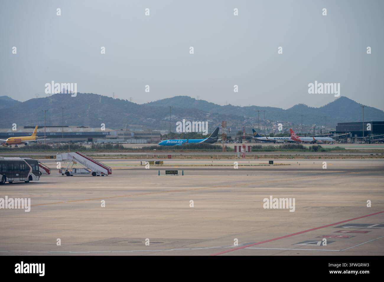 Aerei cargo Prime Air e DHL affiancati a jet passeggeri Ryanair e Smartwings nelle strutture di carico e dell'aeroporto di Barcellona El Prat. Bar Foto Stock