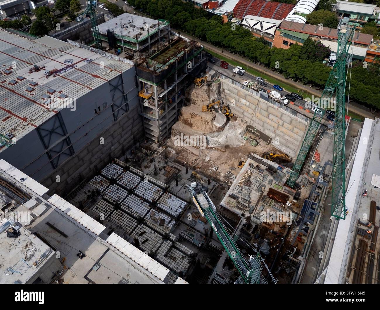 Vista aerea di un grande cantiere edile accanto a edifici commerciali esistenti. Foto Stock