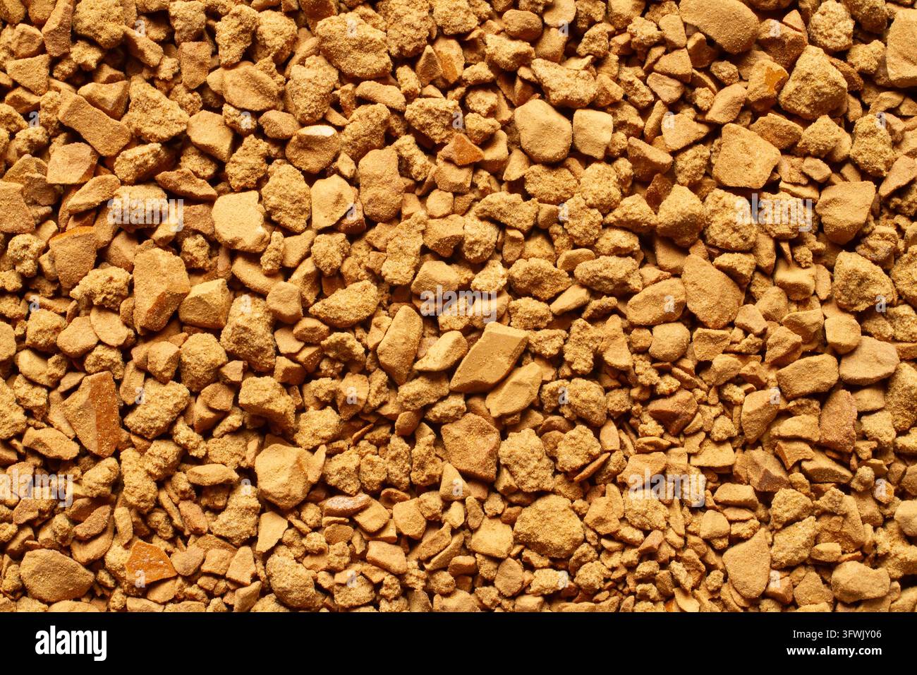 Texture di sfondo macro dettagliata di granuli di caffè istantaneo liofilizzati marroni. Vista a tutto campo delle particelle di caffè solubile che mostrano una struttura ruvida naturale Foto Stock