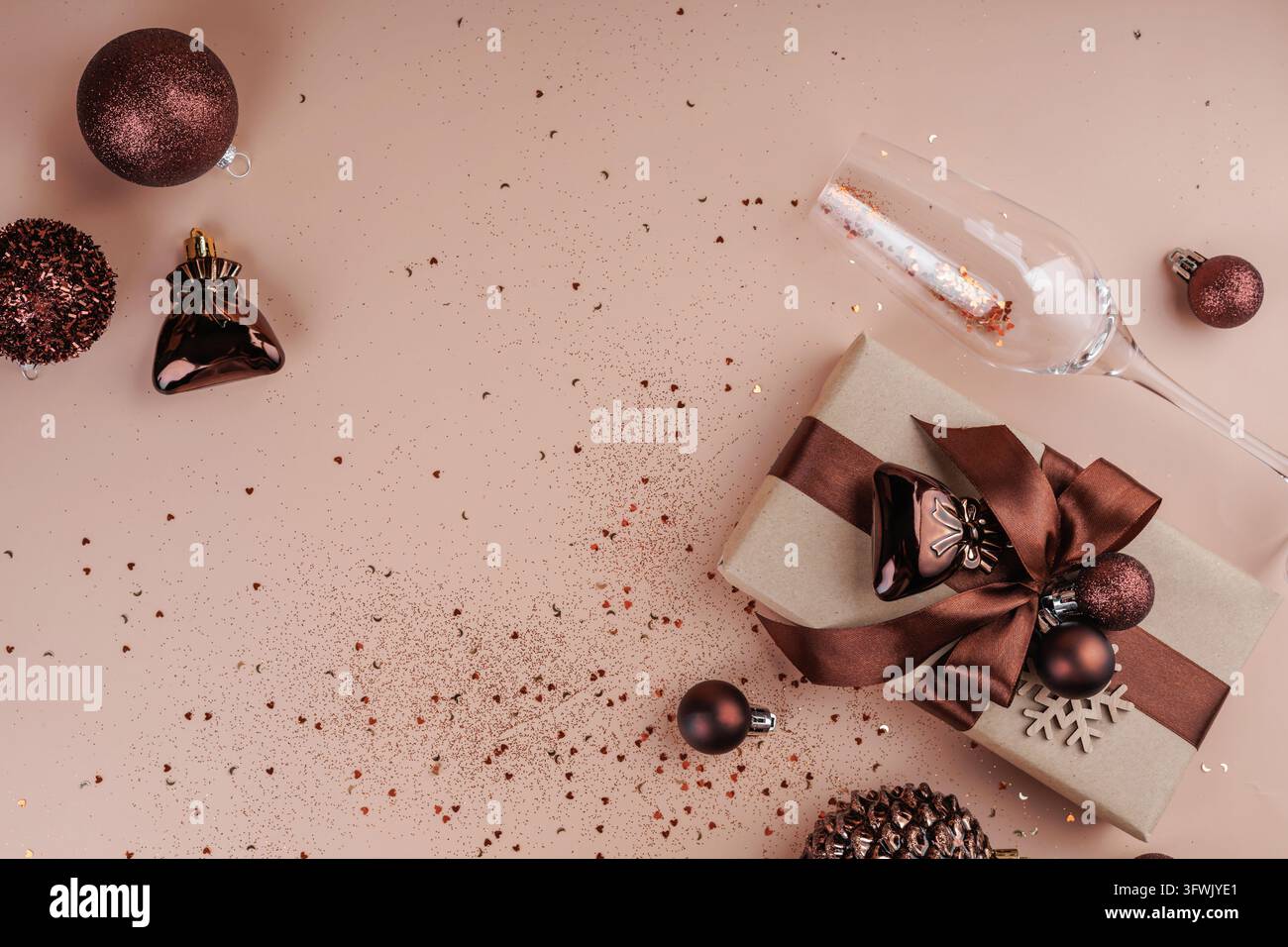 Composizione piatta natalizia con bicchiere di champagne e decorazioni in bronzo Foto Stock