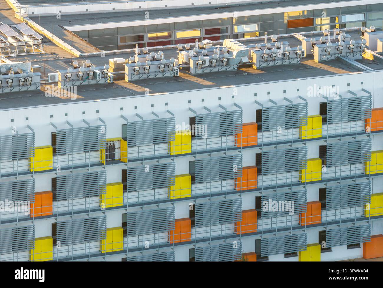 Vista aerea dell'architettura moderna del Campus Morasko con pannelli colorati gialli e arancioni, parasole metallici e unità di ventilazione sul tetto Foto Stock