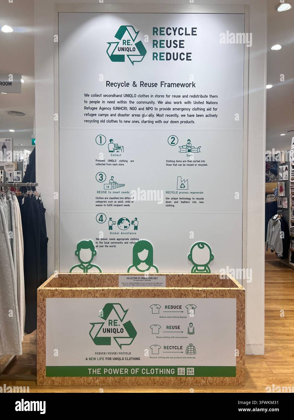 Vista verticale. Uniqlo offre una scatola di riciclo per riciclare i loro vecchi abiti, pratiche etiche ecologiche, dare una seconda vita ai vestiti. Azienda giapponese. - Immagine stock catturata con smartphone