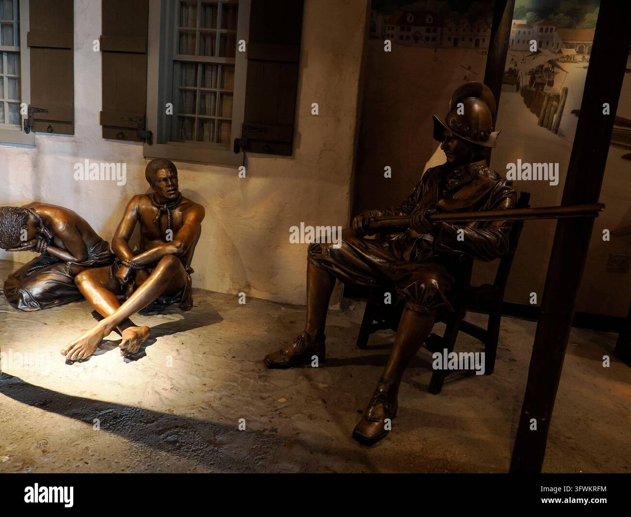 CINCINNATI, USA - 7 SETTEMBRE 2024: Sculture in bronzo del museo che raffigurano figure schiavizzate incatenate sedute sul pavimento sorvegliate da una guardia coloniale armata Foto Stock