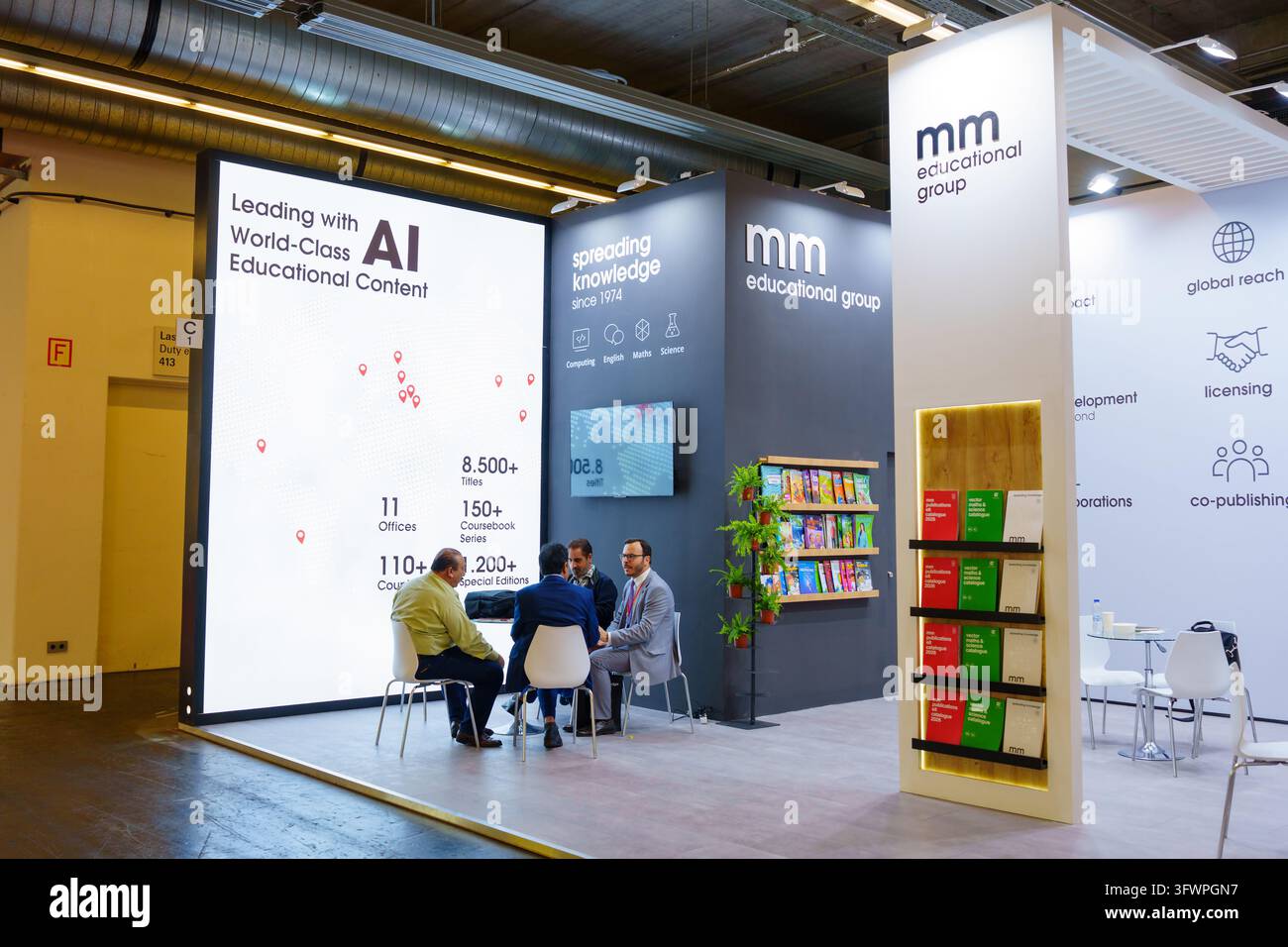 Francoforte, Germania – 7 ottobre 2026: Ambientazione professionale cattura rappresentanti aziendali che discutono di innovazioni nell'editoria educativa all'interno di un mo Foto Stock