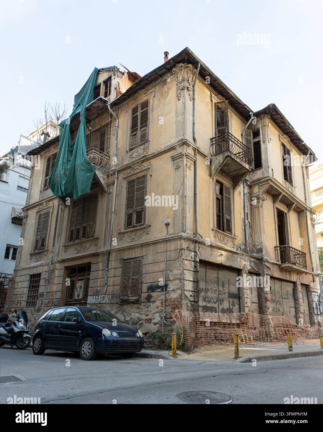 Edificio angolare storico eroso con persiane in legno e balconi Foto Stock