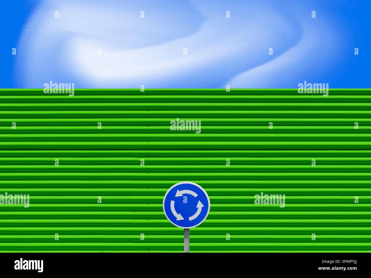 Facciata verde con linee orizzontali, con un cartello stradale, contro un cielo blu con nuvole ondulate. Foto Stock