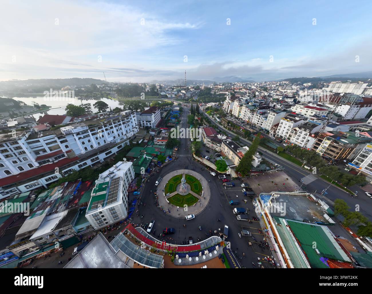 Vista aerea del rondò centrale vicino al lago Xuan Huong circondato da edifici urbani, alberi rigogliosi e strade a Da Lat, Lam Dong, Vietnam. Foto Stock