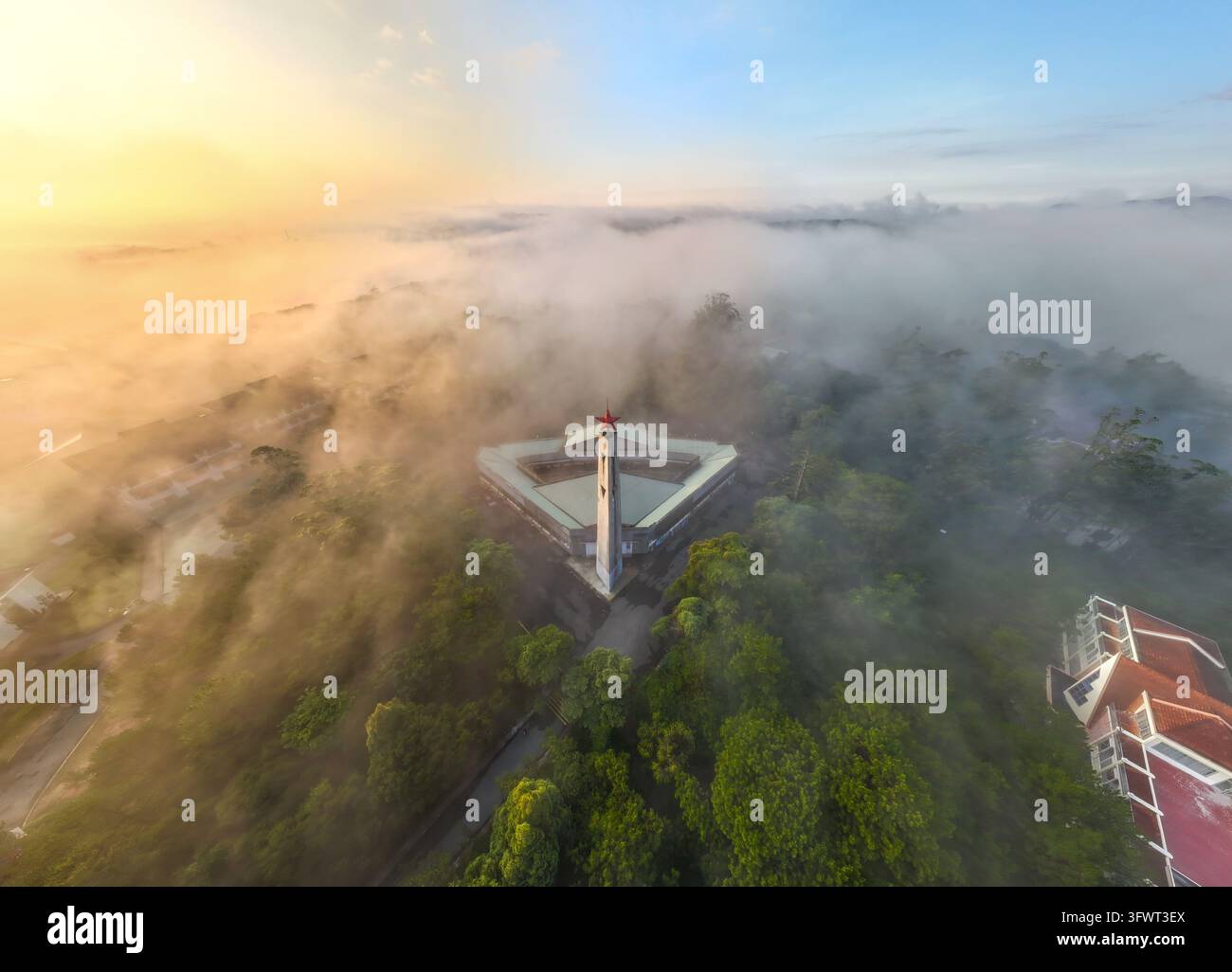 Vista aerea del monumento circondato da alberi verdi lussureggianti e nebbia mattutina a Da Lat, Lam Dong, Vietnam. Foto Stock