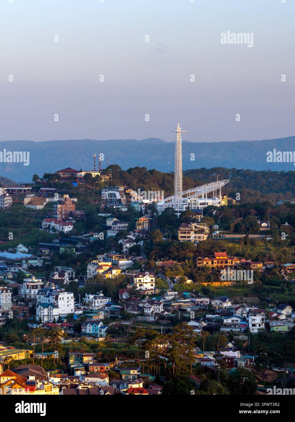Vista aerea della città di Da Lat con la sua torre radiofonica distintiva, abitazioni urbane dense, colline verdi lussureggianti e cielo sereno sullo sfondo, Da Lat, La Foto Stock