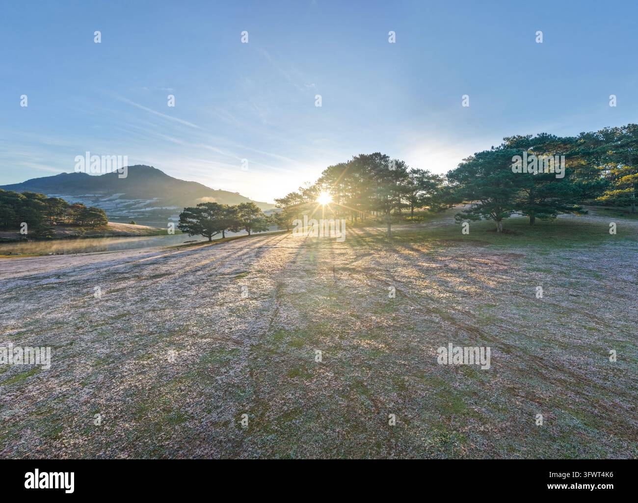 Vista aerea dell'alba sul lago Xuan Huong circondato da pini e campi erbosi a Da Lat, Lam Dong, Vietnam. Foto Stock