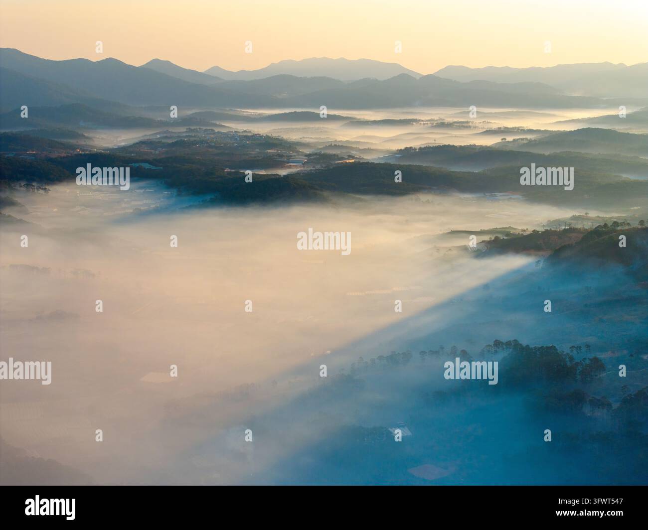 Vista aerea della nebbia che copre le colline ondulate e le foreste di pini delle Alti Pianure Centrali all'alba a Da Lat, Lam Dong, Vietnam Foto Stock