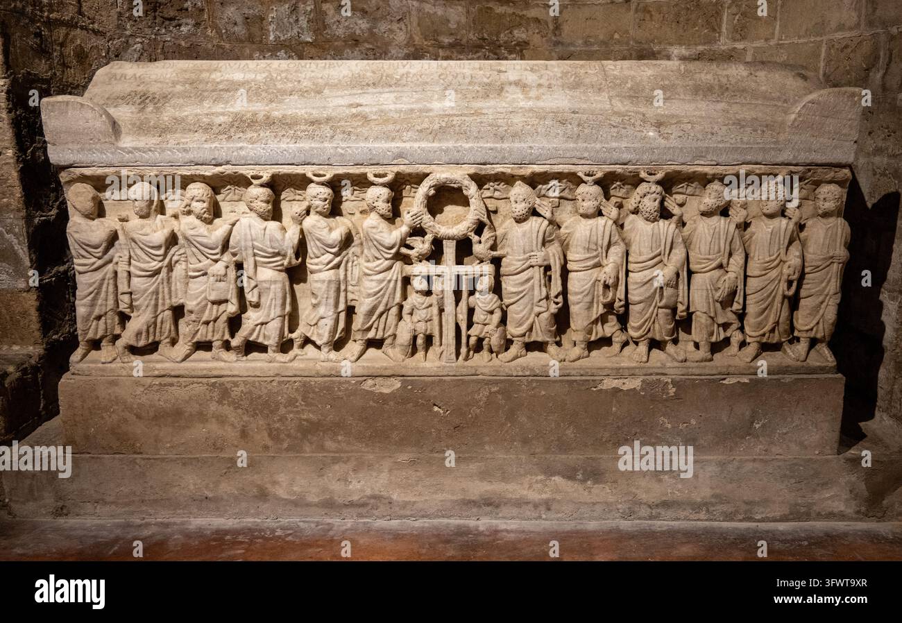 Un sarcofago di pietra decorato con figure in piedi, una ghirlanda e una croce è esposto nella cripta della Cattedrale di Palermo, Palermo, Sicilia, Italia. Foto Stock