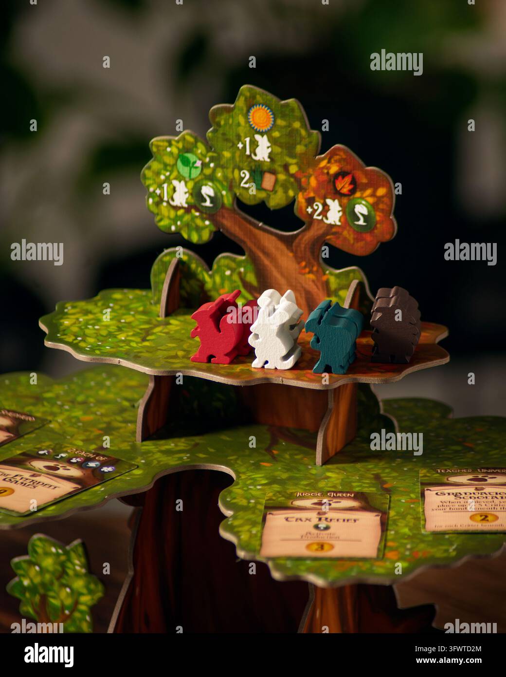 Queretaro, Queretaro, 10 10 2026. Componenti del gioco da tavolo Everdell esposti sulla superficie di gioco sotto una luce drammatica. Ritratto in primo piano che mostra th Foto Stock