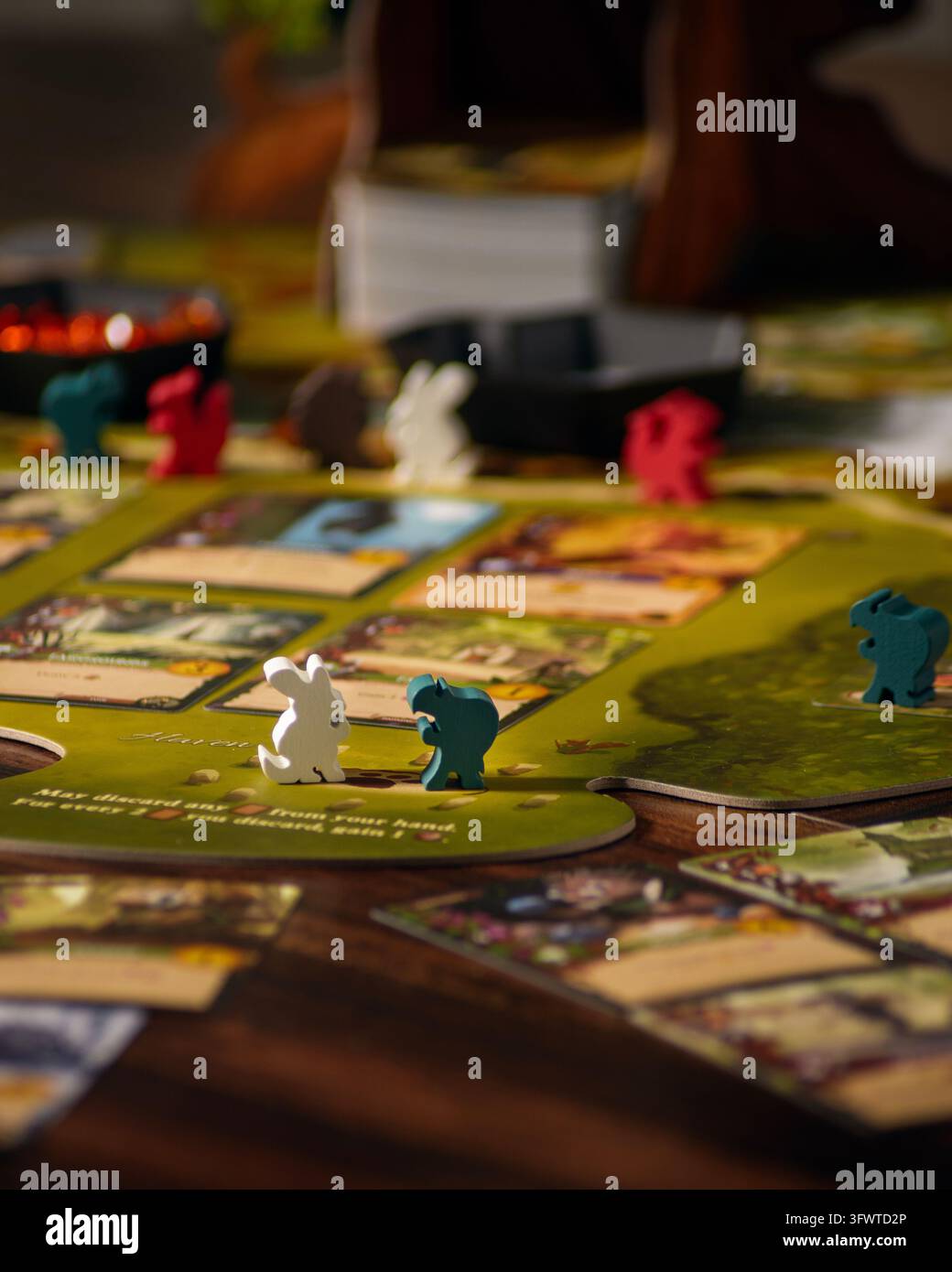Queretaro, Queretaro, 10 10 2026. Componenti del gioco da tavolo Everdell esposti sulla superficie di gioco sotto una luce drammatica. Ritratto in primo piano che mostra th Foto Stock
