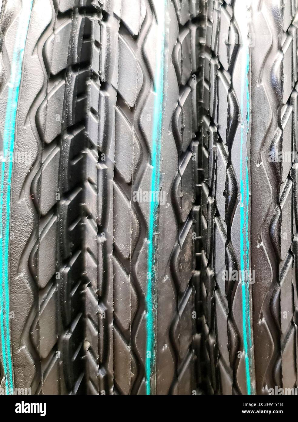 Pneumatici di camion impilati che evidenziano il battistrada e le marcature della parete laterale creano una ripetizione visiva interessante Foto Stock