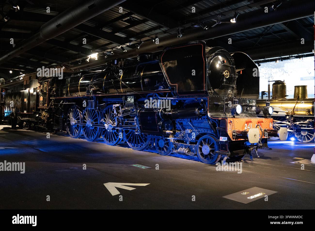 Rixheim, Francia - 24 gen 26: Locomotiva a vapore nera Mountain 241 A1 conservata, costruita nel 1925, esposta sotto luce blu alla Cité du Train di Mulhou Foto Stock