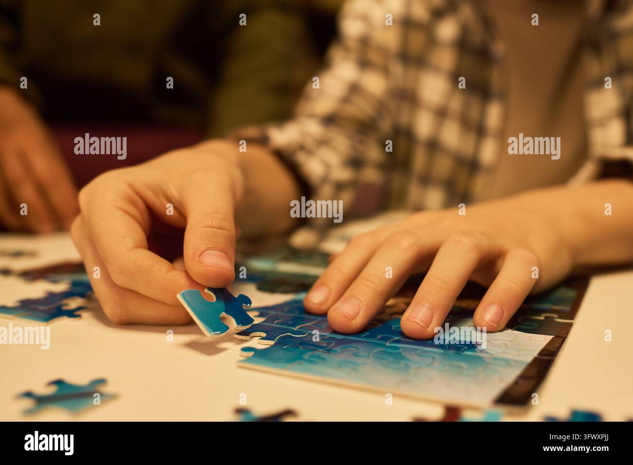 Mani di adolescente che assemblano un puzzle per l'allenamento cerebrale Foto Stock