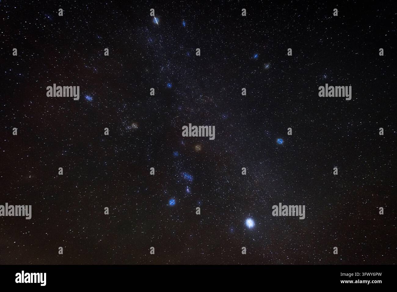 Un campo fitto di stelle riempie il cielo notturno scuro con stelle luminose prominenti visibili contro la Via Lattea. Lo spazio profondo e i colori celesti sottili creano uno sfondo astronomico drammatico Foto Stock