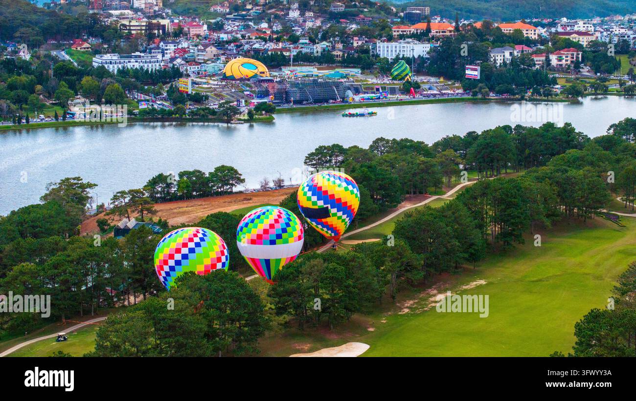 Vista aerea di palloni aerostatici colorati che galleggiano sopra le foreste di pini e il panoramico lago Xuan Huong a Da Lat, Lam Dong, Vietnam. Foto Stock